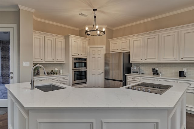 kitchen featuring sink, stainless steel appliances, a notable chandelier, an island with sink, and pendant lighting