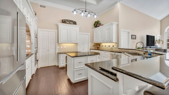 kitchen featuring sink, hanging light fixtures, appliances with stainless steel finishes, a kitchen island, and white cabinets