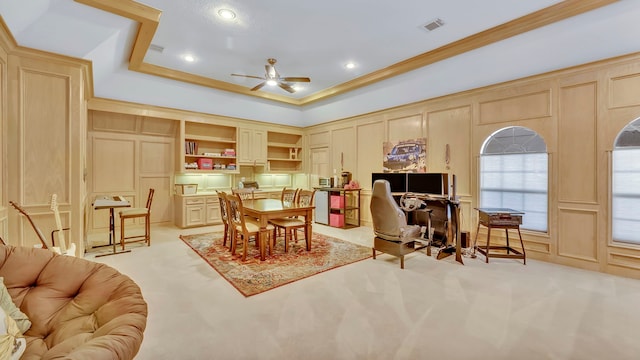 interior space featuring a raised ceiling, ornamental molding, and ceiling fan