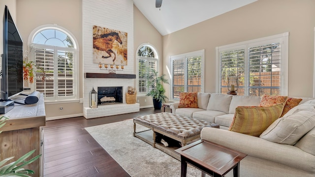 living room with ceiling fan, high vaulted ceiling, dark hardwood / wood-style floors, and a fireplace