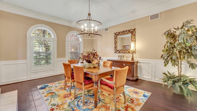 dining area featuring an inviting chandelier, ornamental molding, and dark hardwood / wood-style floors