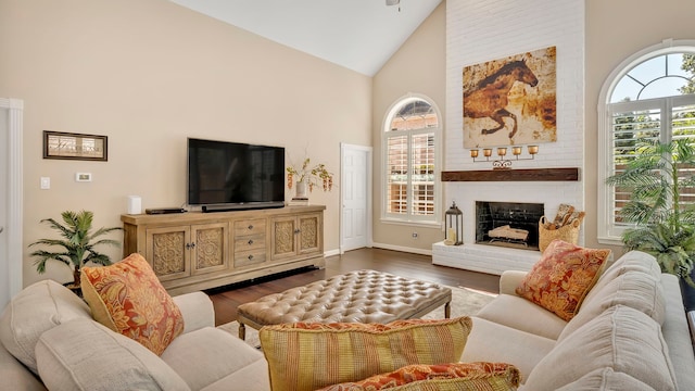 living room with dark wood-type flooring, a fireplace, and high vaulted ceiling