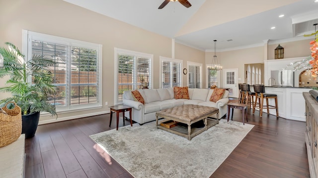 living room with sink, crown molding, high vaulted ceiling, dark hardwood / wood-style floors, and ceiling fan with notable chandelier