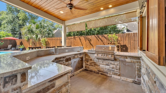 view of patio with area for grilling, ceiling fan, and an outdoor kitchen