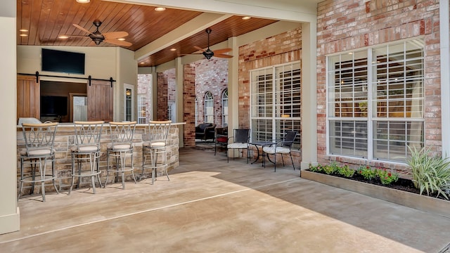 view of patio featuring ceiling fan and an outdoor bar