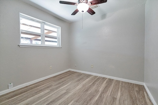 empty room with ceiling fan and light hardwood / wood-style flooring