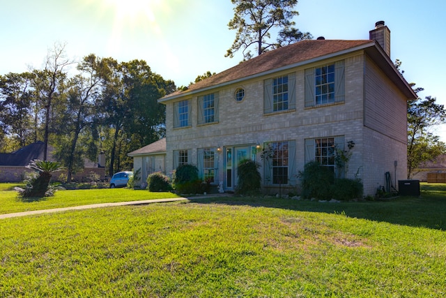 colonial home with central air condition unit and a front yard