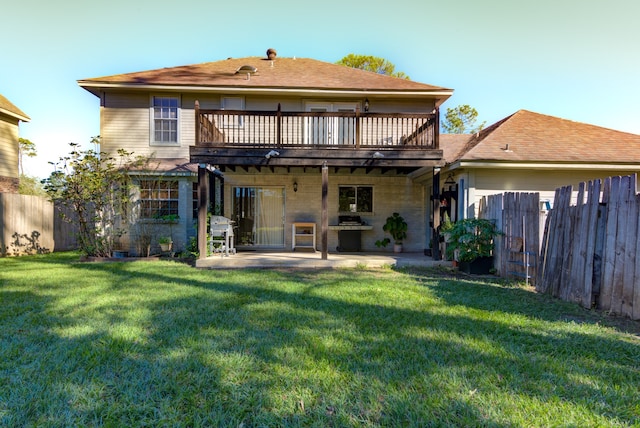 back of property with a lawn and a patio