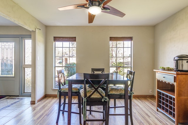 dining room with light wood-type flooring, a wealth of natural light, and ceiling fan