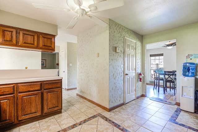 kitchen featuring ceiling fan, light tile patterned floors, and a textured ceiling