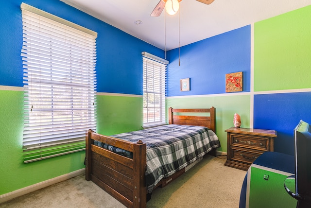 bedroom with multiple windows, light colored carpet, and ceiling fan