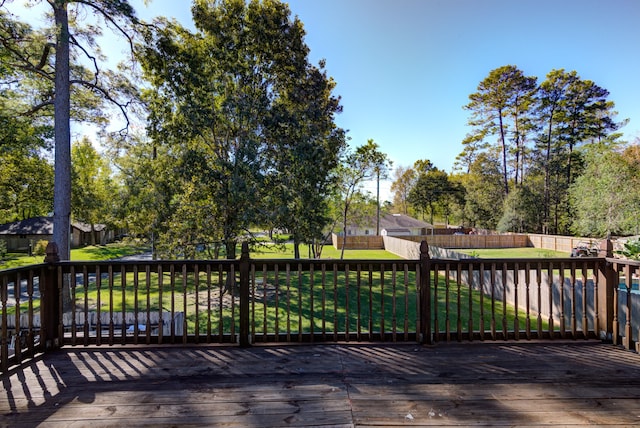 wooden deck featuring a lawn