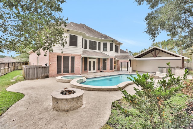 rear view of house with a pool with hot tub, an outdoor fire pit, and a patio