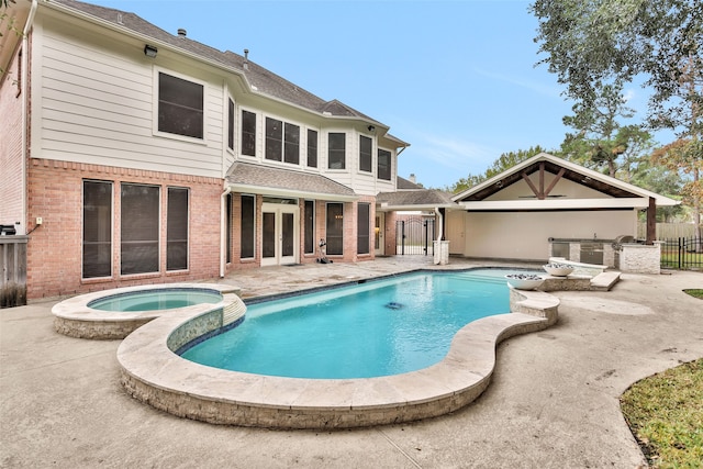 rear view of property featuring area for grilling, a patio area, and a swimming pool with hot tub