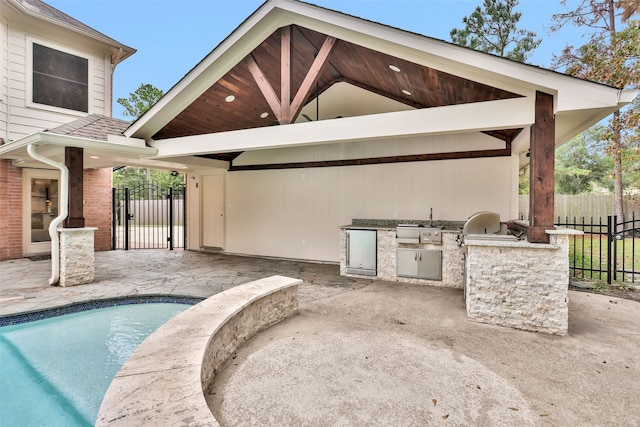 exterior space featuring a fenced in pool and exterior kitchen