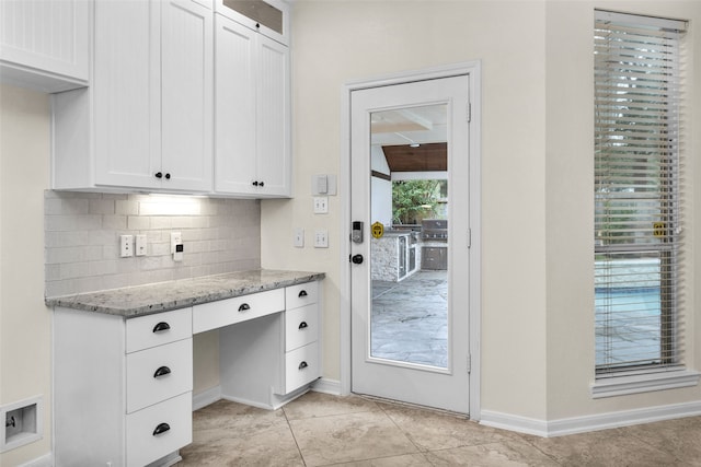 entryway with built in desk and light tile patterned floors