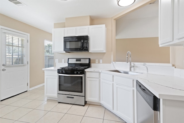 kitchen with white cabinetry, sink, light tile patterned flooring, and stainless steel appliances