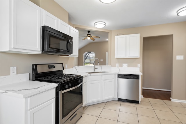 kitchen featuring white cabinetry, sink, stainless steel appliances, lofted ceiling, and light tile patterned floors