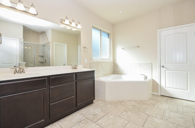 bathroom with vanity and shower with separate bathtub