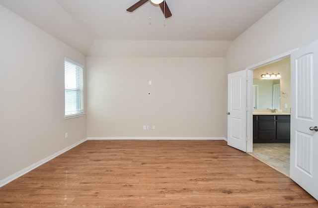 spare room featuring ceiling fan, sink, vaulted ceiling, and light wood-type flooring