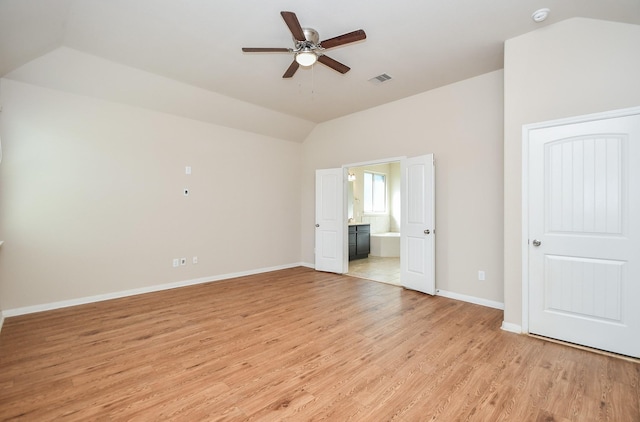 unfurnished bedroom with connected bathroom, ceiling fan, lofted ceiling, and light hardwood / wood-style floors