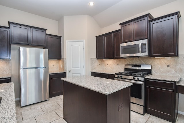 kitchen featuring tasteful backsplash, vaulted ceiling, a center island, stainless steel appliances, and dark brown cabinets