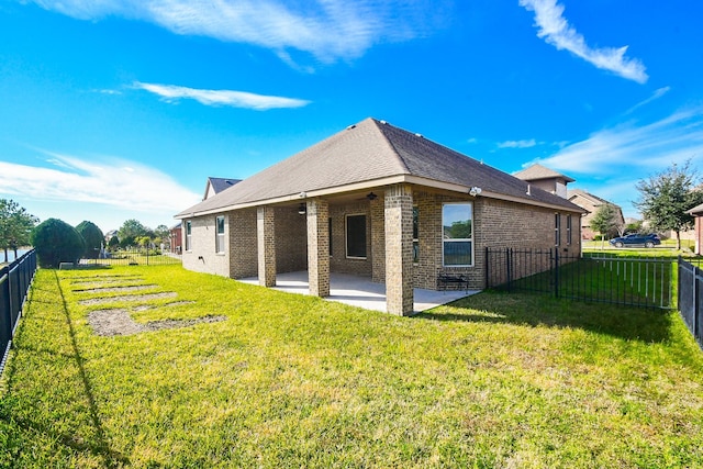 back of house with a lawn and a patio