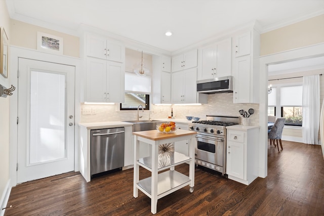 kitchen featuring decorative backsplash, appliances with stainless steel finishes, crown molding, dark hardwood / wood-style floors, and white cabinetry