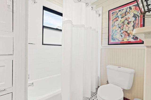 bathroom with shower / bath combo, toilet, and wooden walls