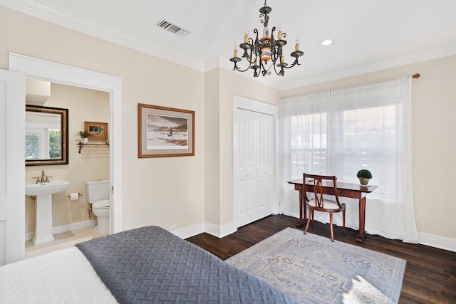 bedroom with dark hardwood / wood-style flooring, ensuite bath, crown molding, an inviting chandelier, and a closet