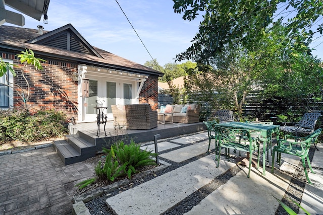 view of patio / terrace featuring a wooden deck, an outdoor living space, and french doors