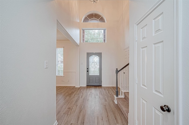 foyer with light wood-type flooring and a high ceiling