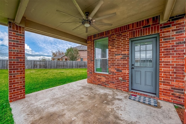 doorway to property featuring a yard, ceiling fan, and a patio area