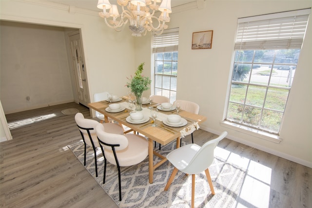 dining space featuring a wealth of natural light, crown molding, an inviting chandelier, and hardwood / wood-style flooring