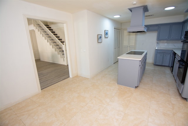 kitchen with a center island, black electric cooktop, custom range hood, and light hardwood / wood-style flooring