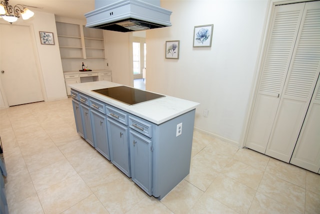 kitchen with a chandelier, black electric stovetop, blue cabinets, and custom exhaust hood