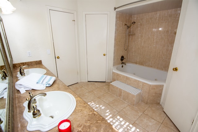 bathroom with tile patterned flooring, tiled shower / bath combo, and vanity