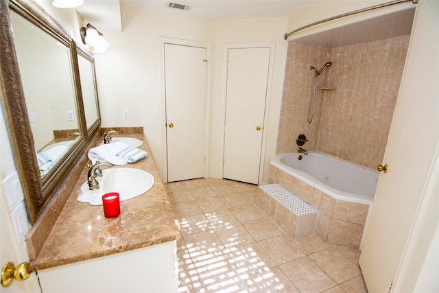 bathroom featuring tile patterned flooring, vanity, and tiled shower / bath combo