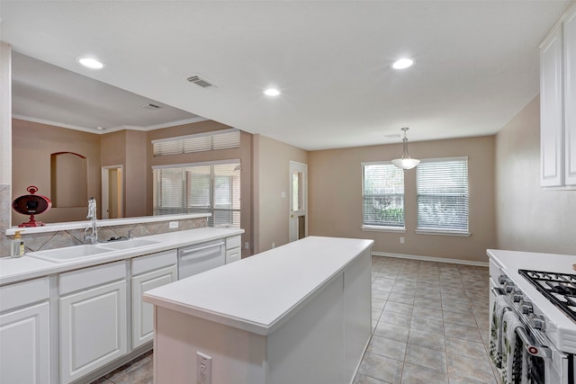 kitchen with dishwasher, sink, hanging light fixtures, a kitchen island, and white cabinets