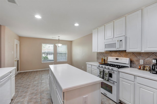 kitchen with white cabinets, a kitchen island, decorative light fixtures, and white appliances