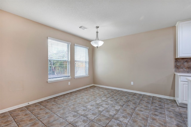 unfurnished dining area featuring light tile patterned floors and a textured ceiling