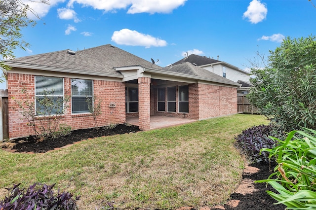 rear view of property with a yard and a patio