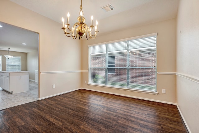 empty room with a notable chandelier and light wood-type flooring