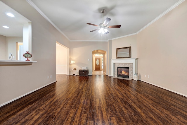 unfurnished living room with dark hardwood / wood-style floors, ceiling fan, ornamental molding, and a tile fireplace