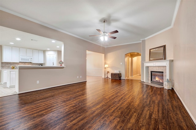 unfurnished living room with hardwood / wood-style floors, ornamental molding, and a fireplace