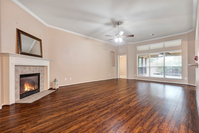 unfurnished living room featuring ceiling fan, crown molding, dark wood-type flooring, and a tile fireplace