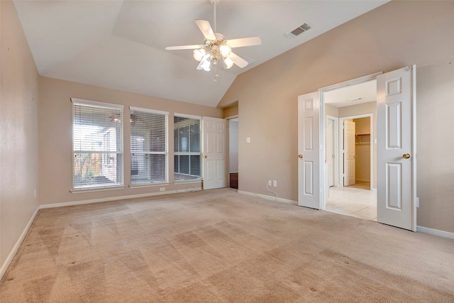 unfurnished room featuring ceiling fan, light colored carpet, and lofted ceiling