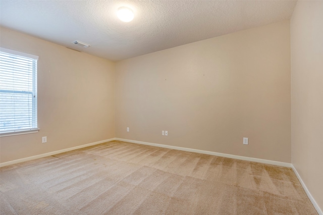 carpeted spare room with a textured ceiling