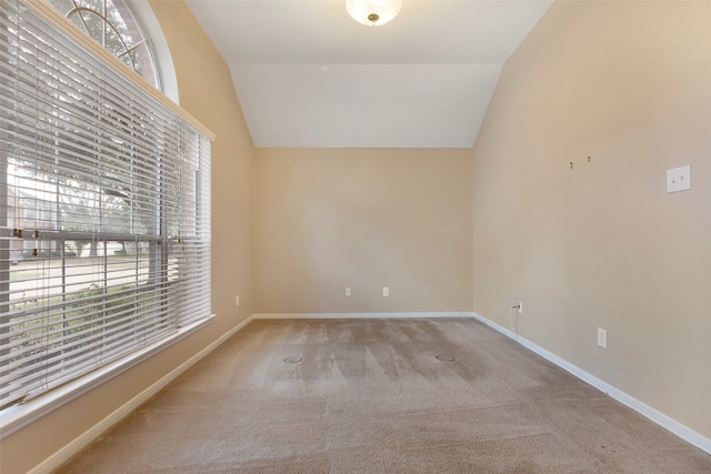 empty room with light carpet and vaulted ceiling