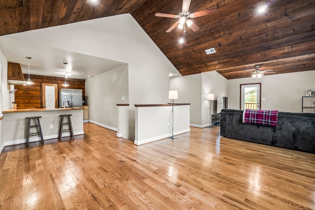 living room with wood ceiling, high vaulted ceiling, and light hardwood / wood-style floors